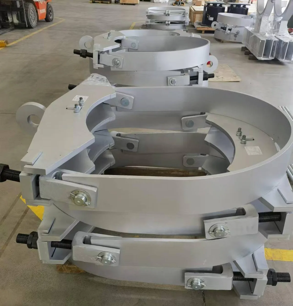Large fabricated pipe clamps arranged in a production batch