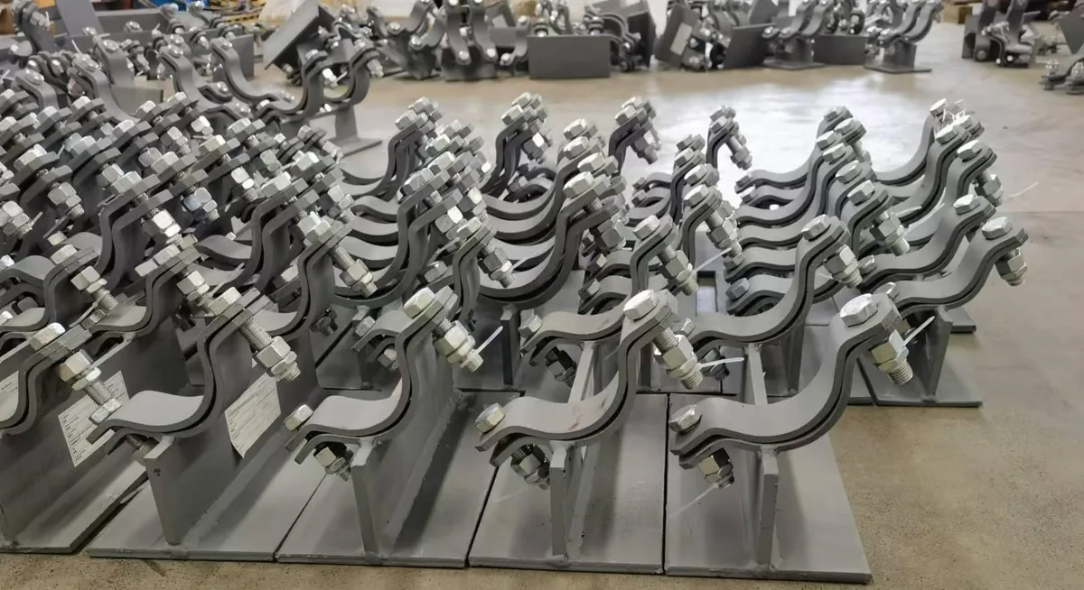 Finished fabricated pipe clamps arranged in production rows