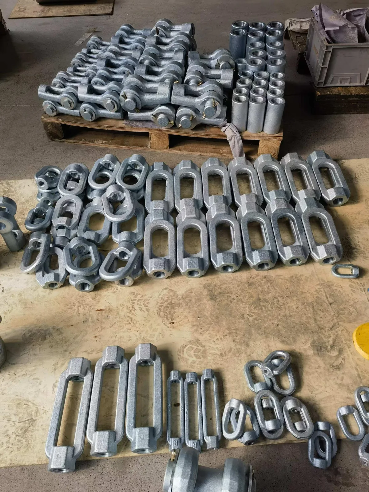 Assorted fabricated pipe support hardware arranged in batches
