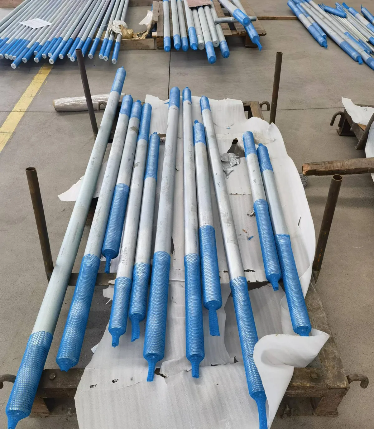 Batch of long threaded rods and connecting hardware on the factory floor